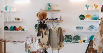 Prateleiras brancas com loiça colorida e peixes decorativos na parede